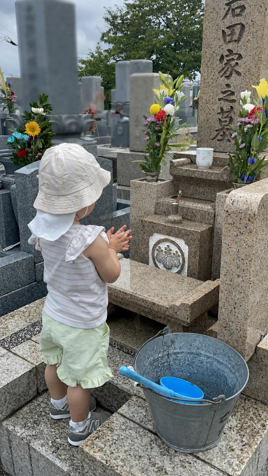 墓前で手を合わせるお子さまの後ろ姿